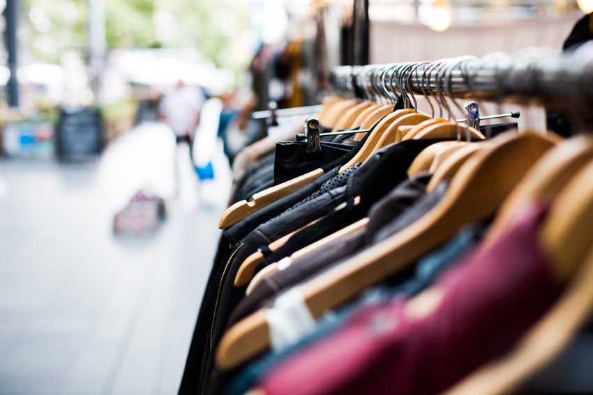 boutique style clothing hanging on a rack outside