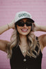 A woman wearing a two toned gameday hat and sunglasses